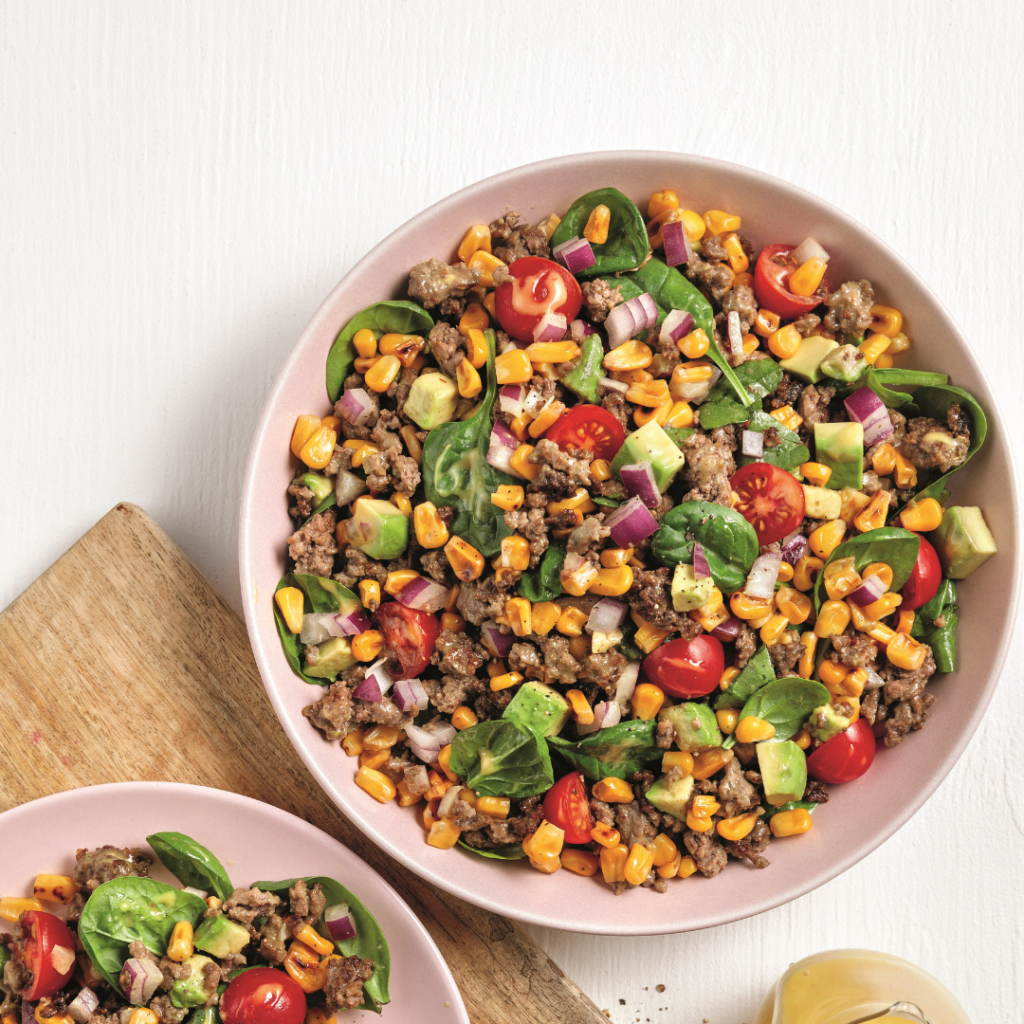 Salade de bœuf et maïs avec tomates, avocat et épinards.