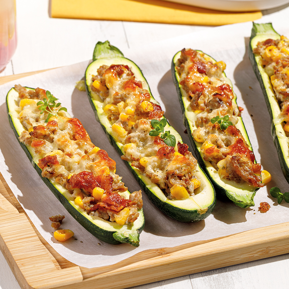 Courgettes farcies au poulet, maïs, bacon et fromage gratiné.