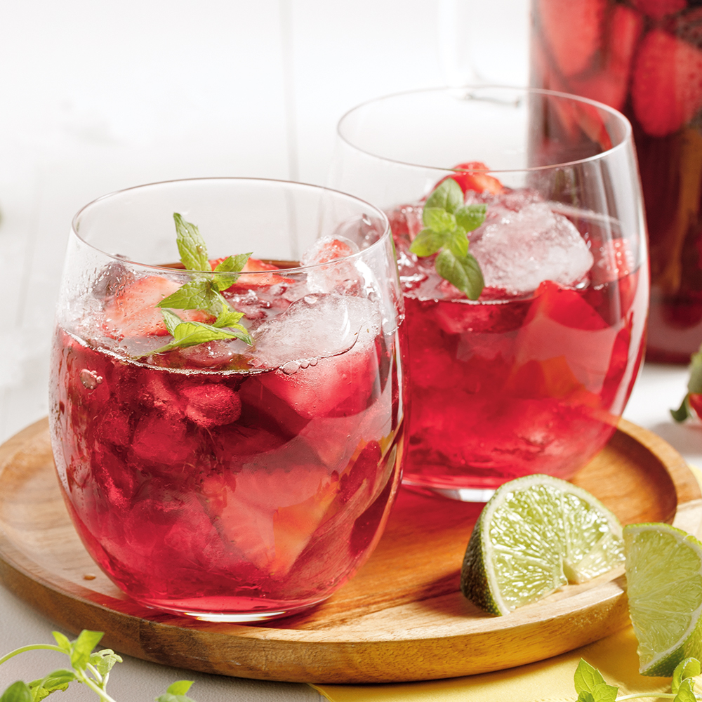 Verre garni de fraises fraîches et de fruits rouges.