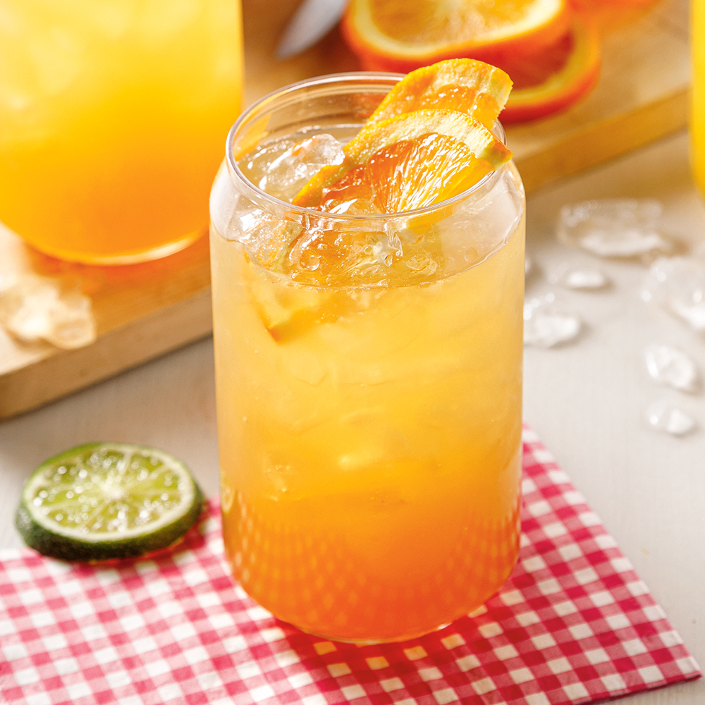 Verre de sangria à l'orange et à la bière garni de tranches d'orange.