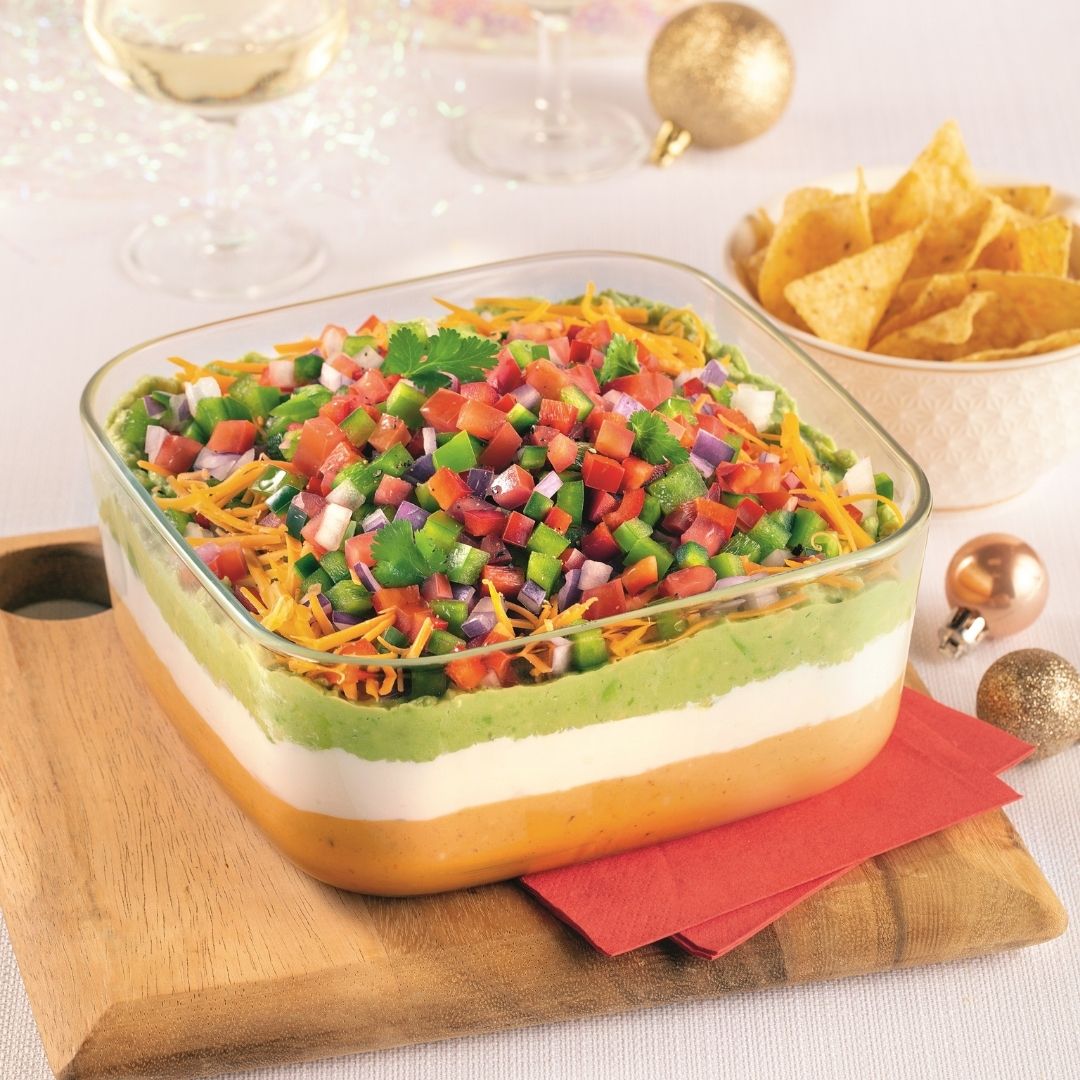 Trempette étagée style nachos garnie de salsa, guacamole et crème sure.