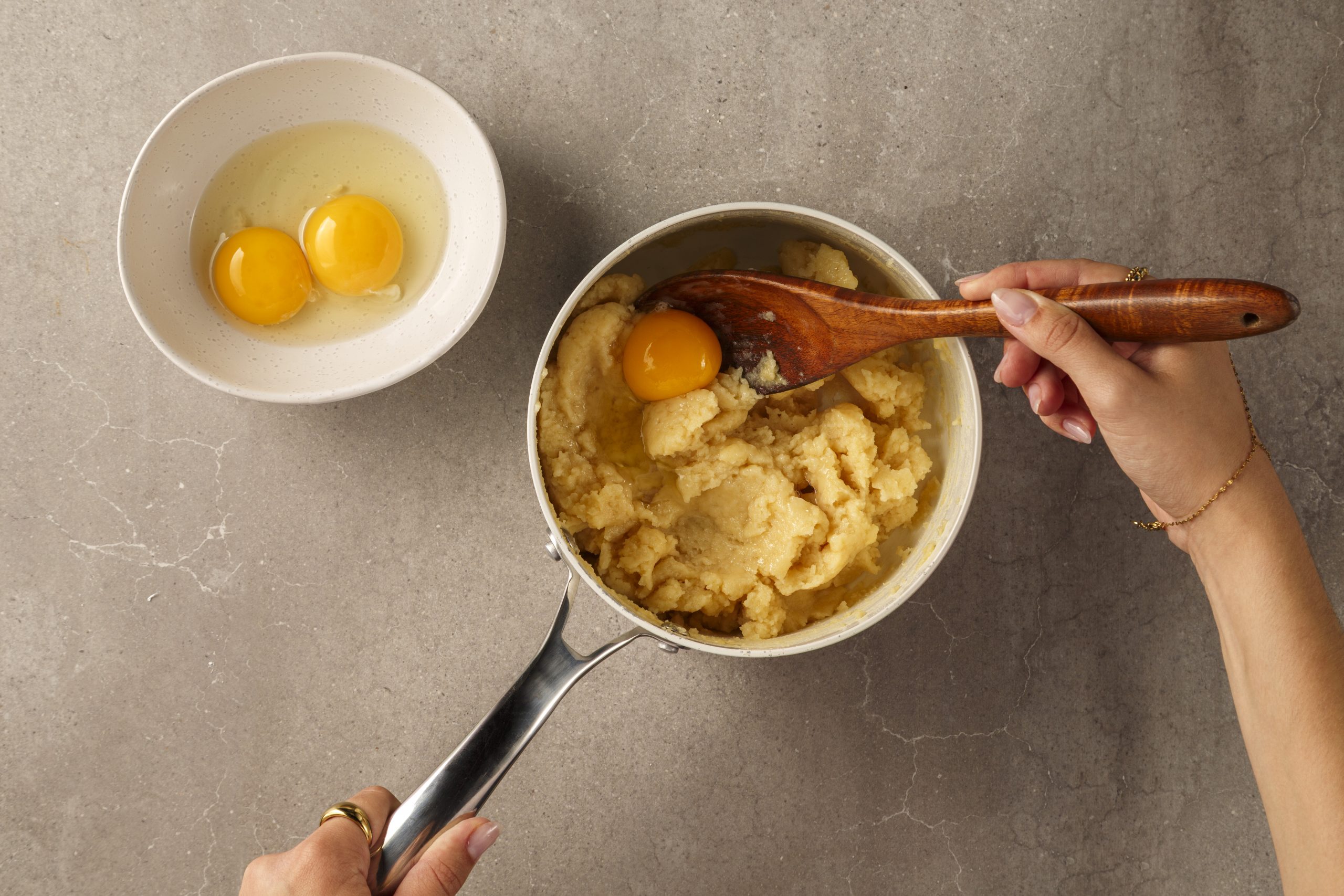 Œufs incorporés un à un dans la pâte à choux